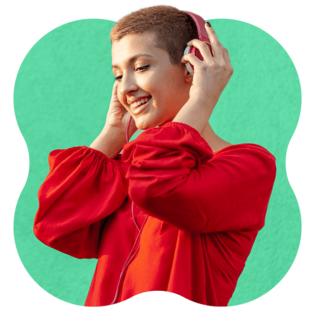 smiling person with short hair listens to music on pink headphones.